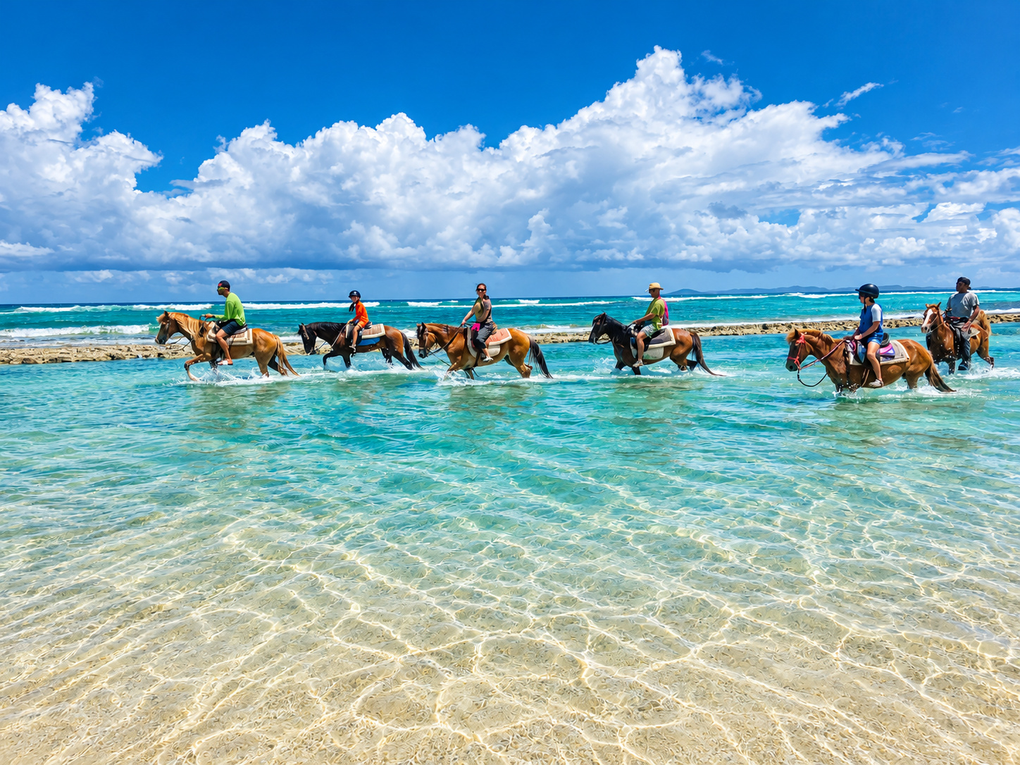 Horseback riders crossing clear coastal shallows